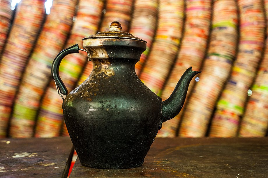 Na treku Xidang - Yubeng: czajnik na tle ściany z pudełek po zupkach (Yunnan (Chiny) 2012, część 1/2)